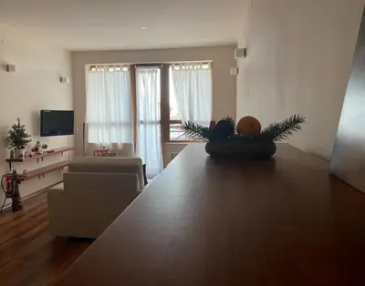 a living room with a table and a living room with a couch at Apartment at White Lavina Hotel in Bansko
