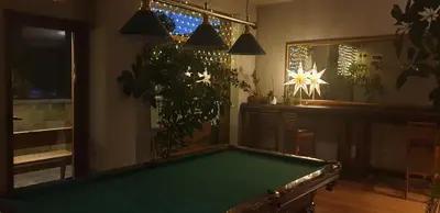 a pool table in a living room with plants at Apartment at White Lavina Hotel in Bansko