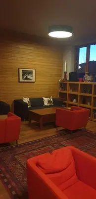 a living room with red chairs and a couch at Apartment at White Lavina Hotel in Bansko