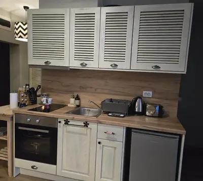 a kitchen with white cabinets and a sink at Apartment at White Lavina Hotel in Bansko