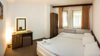 a hotel room with two beds and a mirror at Boriki Complex in Pamporovo