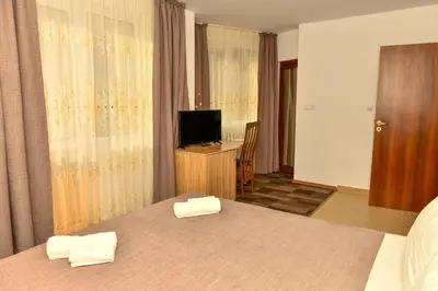 a hotel room with two beds and a television at Blyan Family Hotel in Chiflik