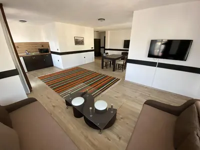 a living room with a couch and a tv and a table at Апартхотел 