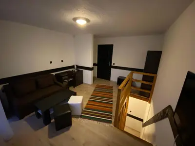 a living room with a couch and a staircase at Апартхотел 