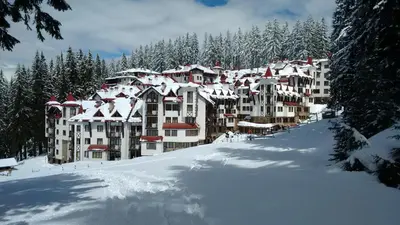 a large building covered in snow on a ski slope at Апартамент 109 Комплекс 