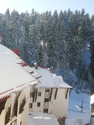 a building covered in snow with trees in the background at Апартамент 109 Комплекс 