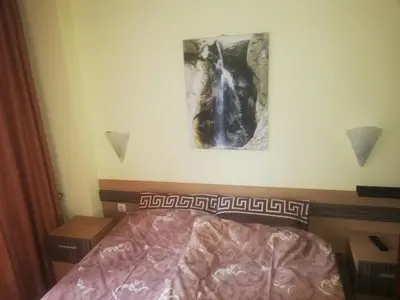 a bed in a bedroom with a picture on the wall at Апартамент 109 Комплекс 