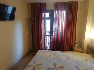 a bedroom with a bed and a window with red curtains at Апартамент 109 Комплекс 