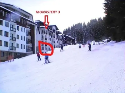 a group of people skiing down a snow covered slope at Ski 'Inn Monastery 3 Ski-to-Door in Pamporovo