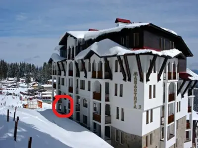 a building with a red circle in the snow at Ski 'Inn Monastery 3 Ski-to-Door in Pamporovo