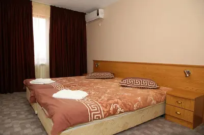 a bedroom with a bed with two pillows on it at Family Prim Hotel in Sandanski
