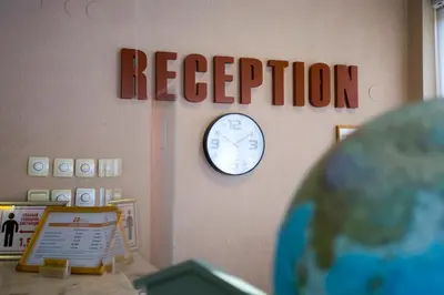 a reception room with a clock on the wall at Family Prim Hotel in Sandanski