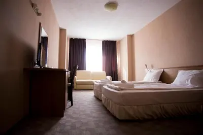 a hotel room with two beds and a window at Family Prim Hotel in Sandanski