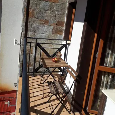 a table and a chair on a balcony at Pamporovo Apartment 314 The Castle 3 in Pamporovo