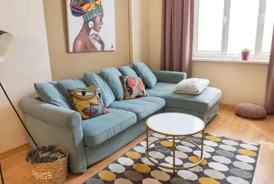 a living room with a blue couch and a table at Apartment Memoir by SofiaSpot - central, metro to airport in Sofia