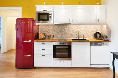 a kitchen with a red refrigerator and white cabinets at Apartment Memoir by SofiaSpot - central, metro to airport in Sofia