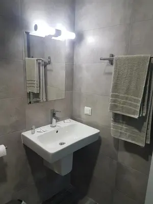 a bathroom with a sink and a mirror and towels at LUXURY SUITES in Karlovo
