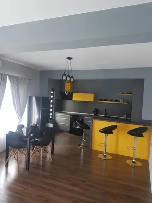 a kitchen with black and yellow walls and a table and chairs at LUXURY SUITES in Karlovo