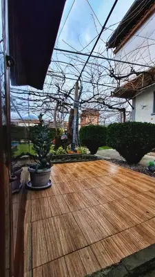 a wooden deck with a statue in a yard at Стаи за гости Върбите in Sapareva Banya