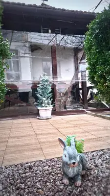 a figurine of a rabbit sitting in front of a house at Стаи за гости Върбите in Sapareva Banya