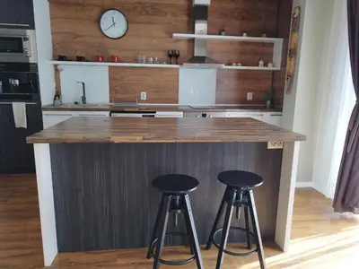 a kitchen with a counter with two stools at LUXURY SUITE 2 in Karlovo