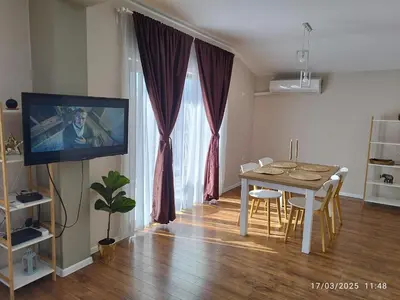 a living room with a dining room table and a tv at LUXURY SUITE 2 in Karlovo