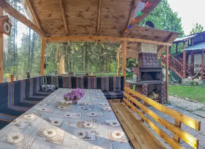 a wooden pavilion with a table and a fireplace at Guest Rooms- KLEPALSKI House in Borovets
