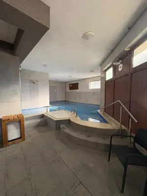 a large room with a swimming pool with stairs at Sapareva Apartments in Sapareva Banya