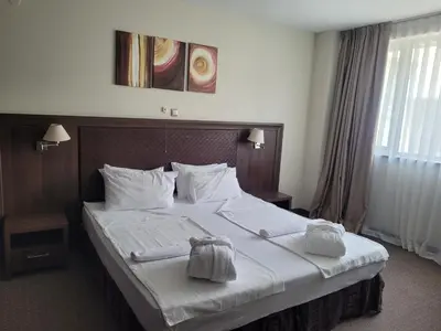a bedroom with a large bed with two towels on it at Sana Spa Hotel in Hisarya