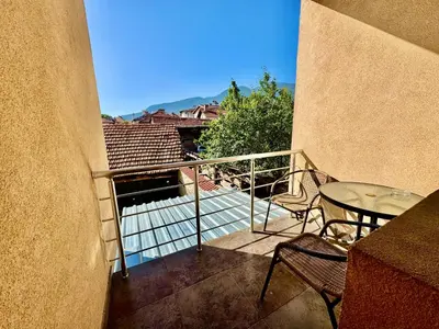 a balcony with a table and a table and chairs at TM HOUSE - Private Rooms in Bansko