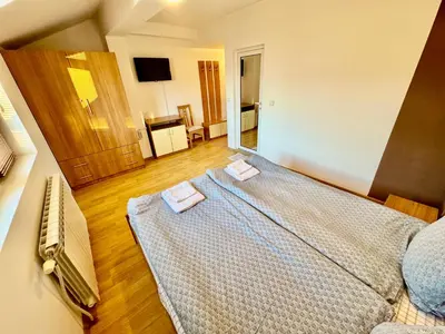 a bedroom with a large bed with two towels on it at TM HOUSE - Private Rooms in Bansko