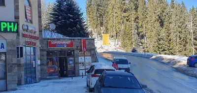 a group of cars parked on a snow covered road at Апартамент Pamporovo Palace in Pamporovo