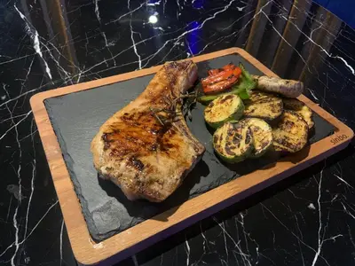 a plate of food with a piece of meat and vegetables at апартамент Мишел (Mishel) in Samokov