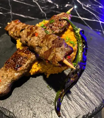 a plate of food with meat and vegetables on a table at апартамент Мишел (Mishel) in Samokov