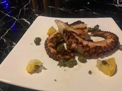 a white plate of food with tentacles and other foods at апартамент Мишел (Mishel) in Samokov