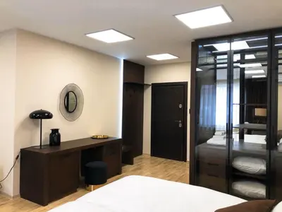 a bedroom with a bed and a desk and a mirror at апартамент Мишел (Mishel) in Samokov