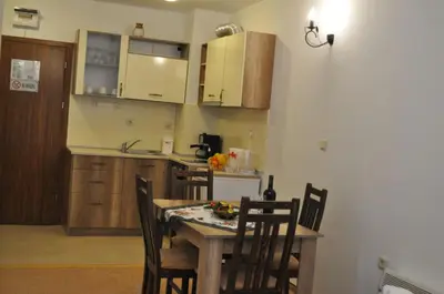 a kitchen with a table and chairs in a room at Апартамент Winter home Iceberg in Pamporovo