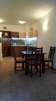 a dining room with a table and chairs and a kitchen at Elitsa Apartment in Pamporovo