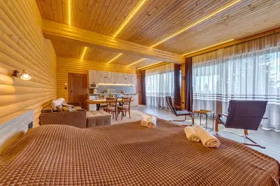 a bedroom with a large bed and a dining room at Вила Морава in Pamporovo