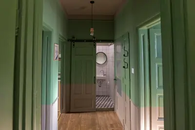 a hallway of a bathroom with green walls and a door at Beautiful best location apartment Green Mouse in Plovdiv