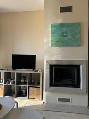 a living room with a fireplace and a tv at Emerald Buddha Apartment in Bansko