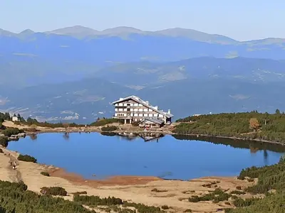 a large building sitting on top of a large lake at Emerald Buddha Apartment in Bansko