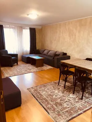 a living room with a couch and a table at Dolomiti Apartments in Bansko