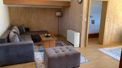 a living room with a couch and a table at Dolomiti Apartments in Bansko