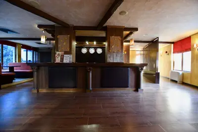 a lobby with a bar with clocks on the wall at Dolomiti Apartments in Bansko
