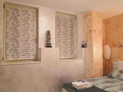 a bedroom with a window with blinds and a bed at Apartment Unique in Plovdiv