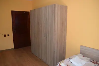 a wooden cabinet in the corner of a bedroom at Vesi's Rooms in Plovdiv