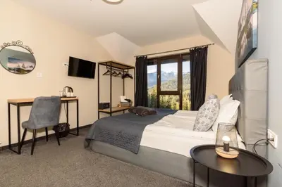 a bedroom with a bed and a desk and a window at Villa Ivan & Petar in Semkovo