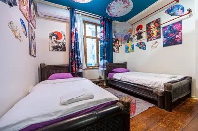 two beds in a room with paintings on the walls at Central House for up to 16 Guests Entire Place in Sofia