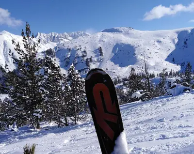 a snowboard is standing in the snow on a mountain at Sunny studio apartment - few steps from Gondola in Bansko